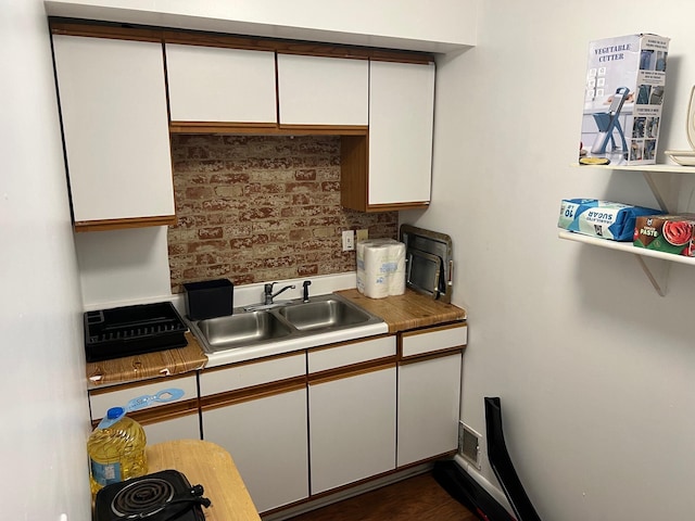 kitchen featuring white cabinetry, dark wood-type flooring, and sink