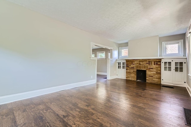 75 N Huron Ave, Columbus, OH 43204 - unfurnished living room featuring a textured ceiling, dark wood-style flooring, and a fireplace