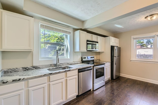 75 N Huron Ave, Columbus, OH 43204 - kitchen featuring appliances with stainless steel finishes, a textured ceiling, dark wood-type flooring, light stone counters, and white cabinets