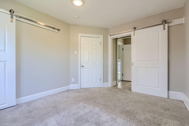 75 N Huron Ave, Columbus, OH 43204 - unfurnished bedroom featuring a barn door, carpet floors, and a closet