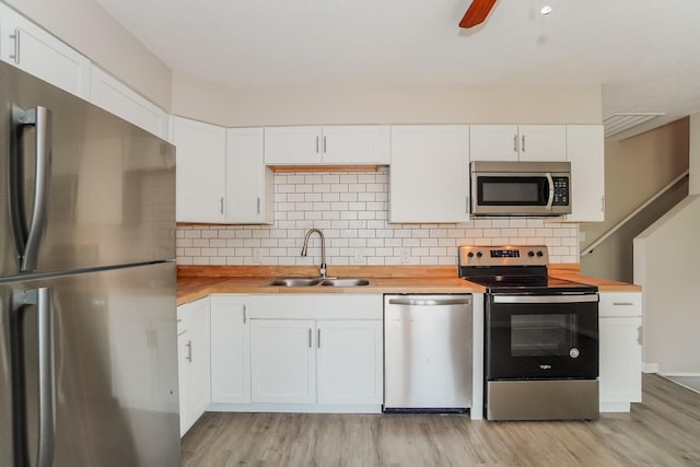 kitchen with butcher block counters, sink, white cabinets, and appliances with stainless steel finishes