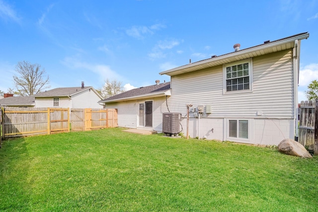 back of house featuring central AC unit and a yard