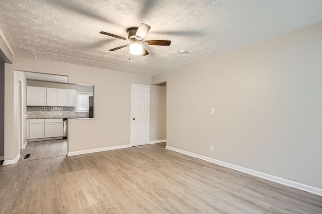 unfurnished living room with a textured ceiling, light hardwood / wood-style flooring, and ceiling fan