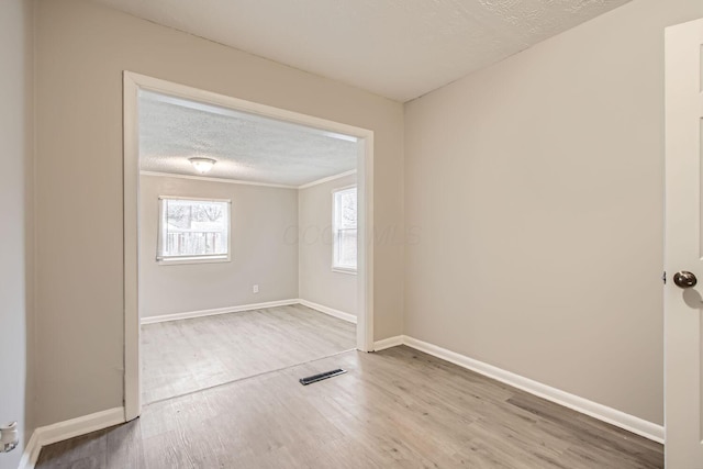 spare room with a textured ceiling and hardwood / wood-style flooring