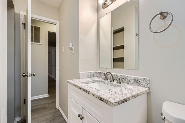 bathroom featuring hardwood / wood-style floors, vanity, and toilet