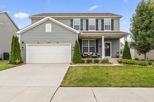 view of front of house featuring a front lawn, covered porch, and a garage