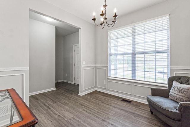 sitting room with dark hardwood / wood-style floors, an inviting chandelier, and plenty of natural light