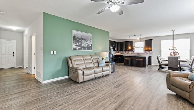 living room with ceiling fan and wood-type flooring