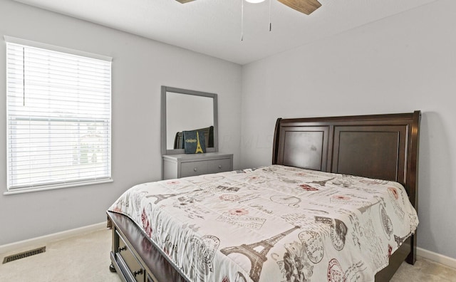 bedroom with light colored carpet, multiple windows, and ceiling fan