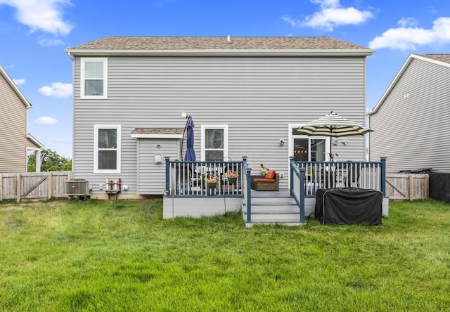 back of house featuring central air condition unit, a deck, and a lawn