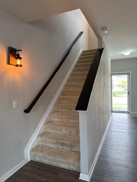 stairs featuring hardwood / wood-style floors