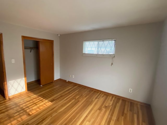 unfurnished bedroom with a closet and hardwood / wood-style floors