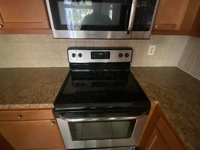 kitchen featuring light stone countertops, appliances with stainless steel finishes, and tasteful backsplash