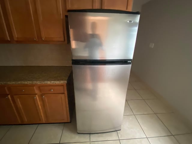 kitchen with stainless steel fridge and light tile patterned floors