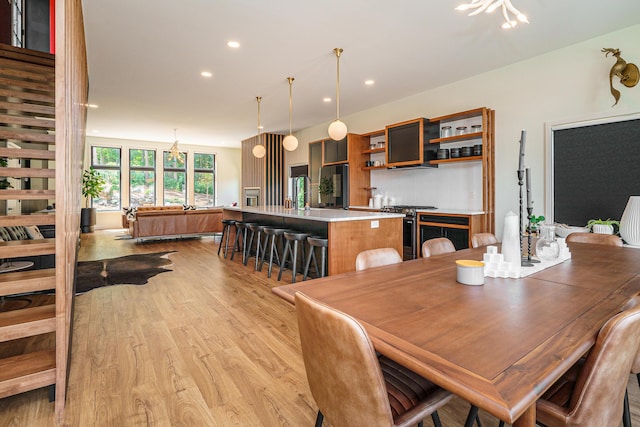 dining space with light hardwood / wood-style flooring and a notable chandelier