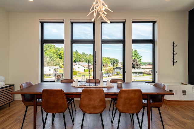 dining area featuring hardwood / wood-style flooring and a notable chandelier