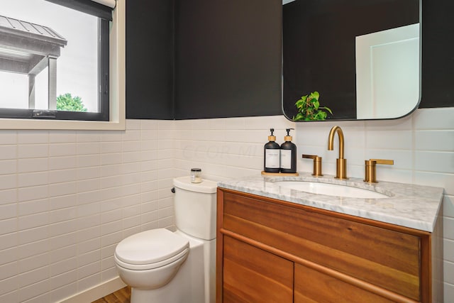 bathroom featuring hardwood / wood-style floors, vanity, toilet, and tile walls