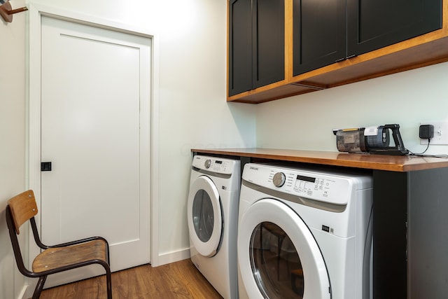 laundry area featuring separate washer and dryer, cabinets, and hardwood / wood-style flooring