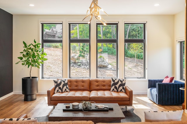 living room featuring a chandelier, light hardwood / wood-style floors, and plenty of natural light