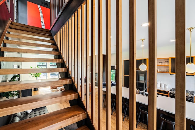 staircase featuring sink and wood-type flooring