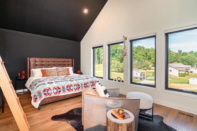 bedroom featuring hardwood / wood-style flooring and high vaulted ceiling