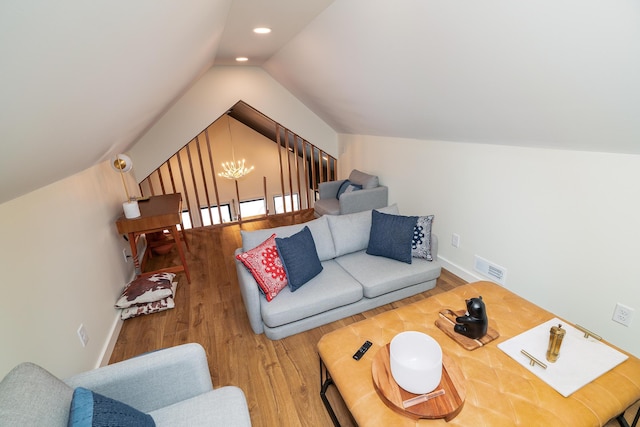 living room with a notable chandelier, vaulted ceiling, and hardwood / wood-style flooring