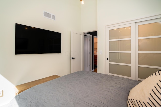 unfurnished bedroom featuring hardwood / wood-style floors and a towering ceiling