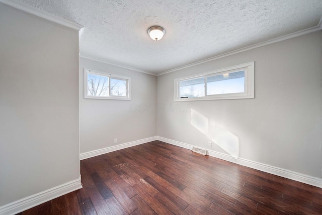 spare room featuring a textured ceiling, dark wood-type flooring, and a healthy amount of sunlight