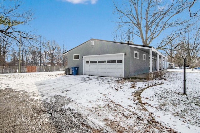 snow covered property with a garage