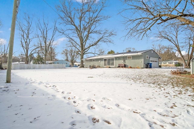 snow covered property with a garage