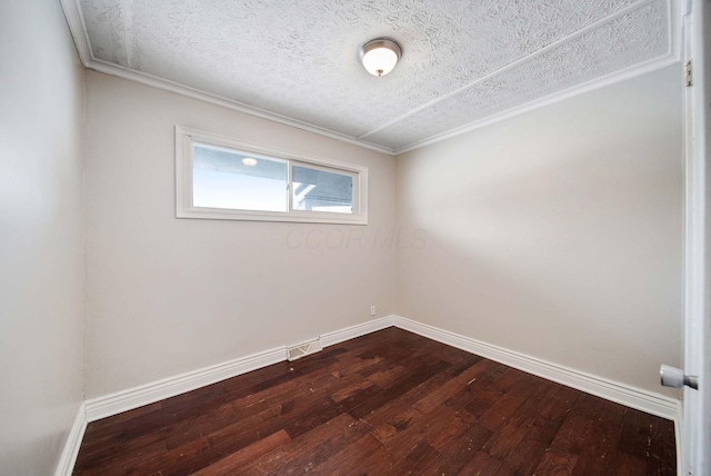 spare room featuring hardwood / wood-style flooring, crown molding, and a textured ceiling