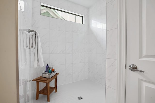 bathroom with tiled shower and tile walls