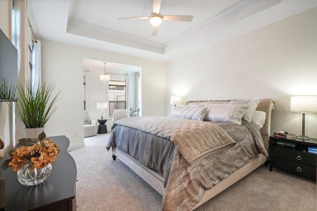 bedroom featuring a tray ceiling, ceiling fan, carpet flooring, and crown molding