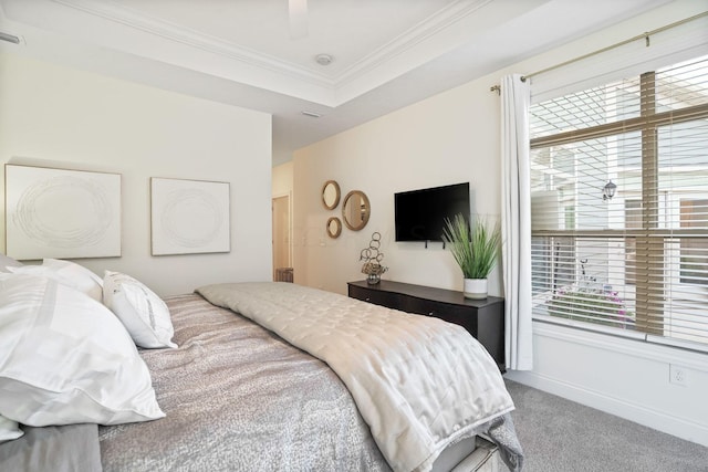 carpeted bedroom with a raised ceiling, ceiling fan, and crown molding