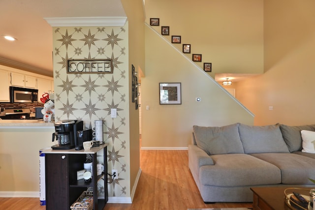 living room with ornamental molding and light wood-type flooring