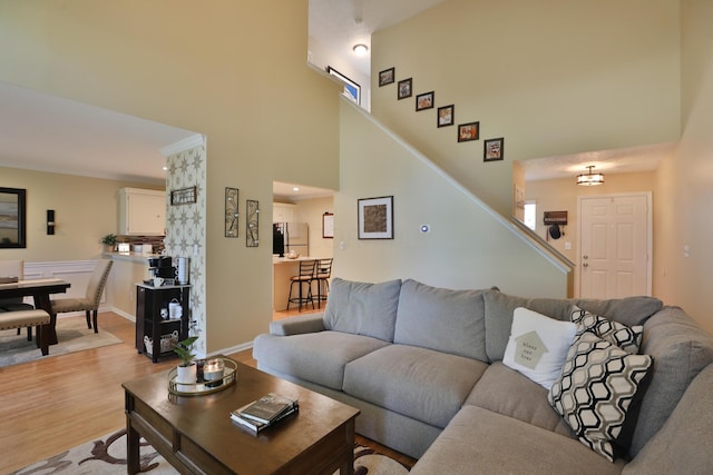 living room featuring a high ceiling and light hardwood / wood-style flooring