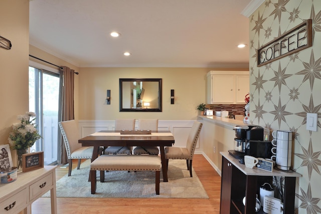 dining space featuring light wood-type flooring and ornamental molding