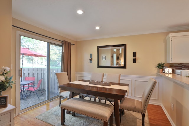 dining space featuring light hardwood / wood-style flooring and ornamental molding