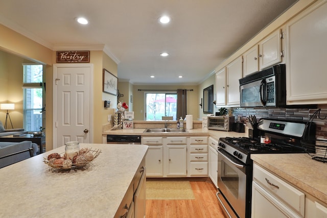 kitchen featuring appliances with stainless steel finishes, white cabinetry, ornamental molding, and sink