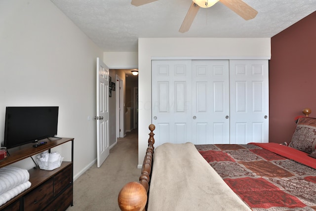 carpeted bedroom featuring ceiling fan, a closet, and a textured ceiling