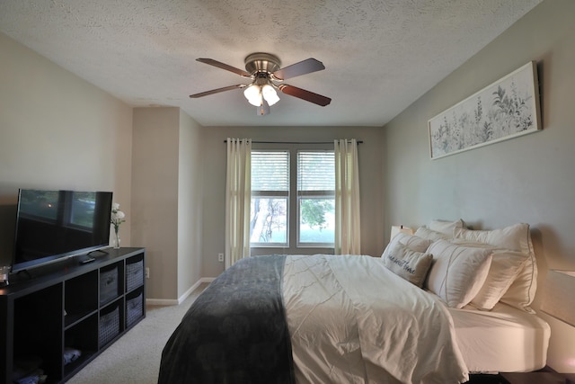 carpeted bedroom featuring ceiling fan and a textured ceiling