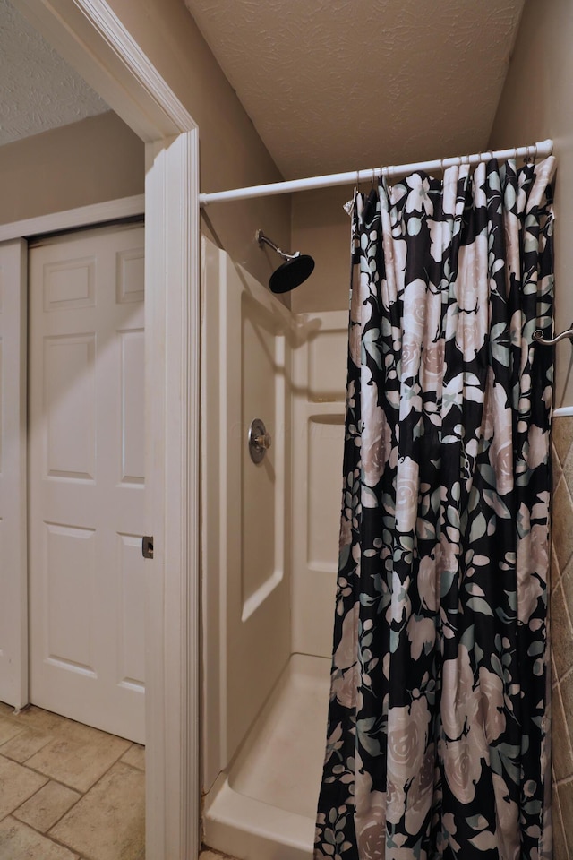 bathroom with a textured ceiling and walk in shower