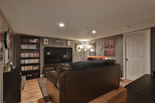 living room featuring light wood-type flooring and a textured ceiling