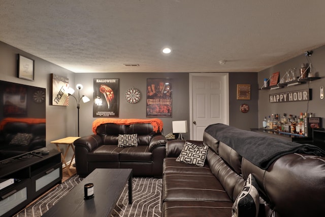 home theater featuring bar and a textured ceiling