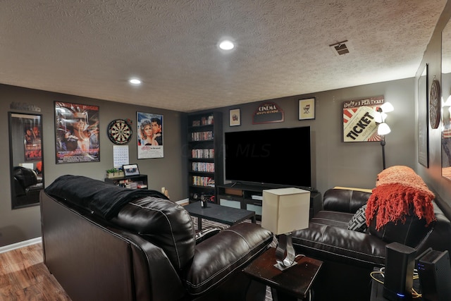 cinema with wood-type flooring and a textured ceiling