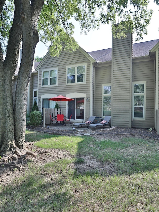 rear view of house with a yard and a patio area