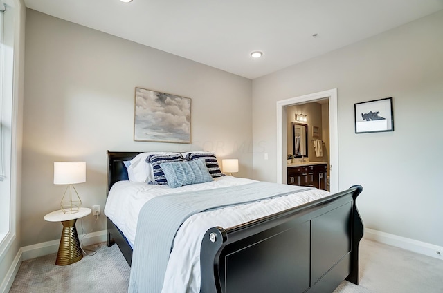 bedroom featuring light colored carpet and ensuite bath