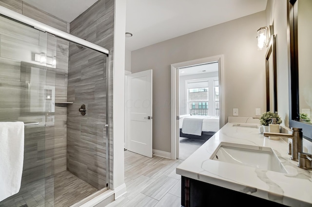 bathroom featuring a shower with door and vanity