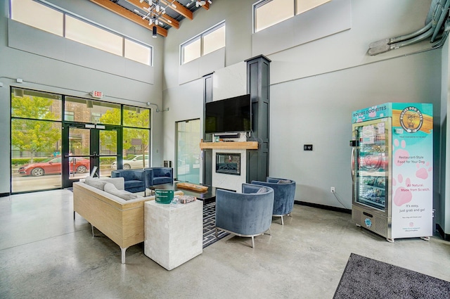 living room with concrete flooring, a high ceiling, and plenty of natural light