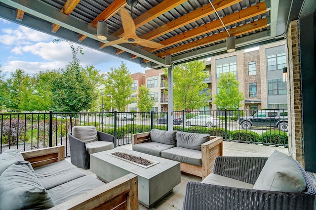 view of patio featuring ceiling fan and an outdoor living space with a fire pit